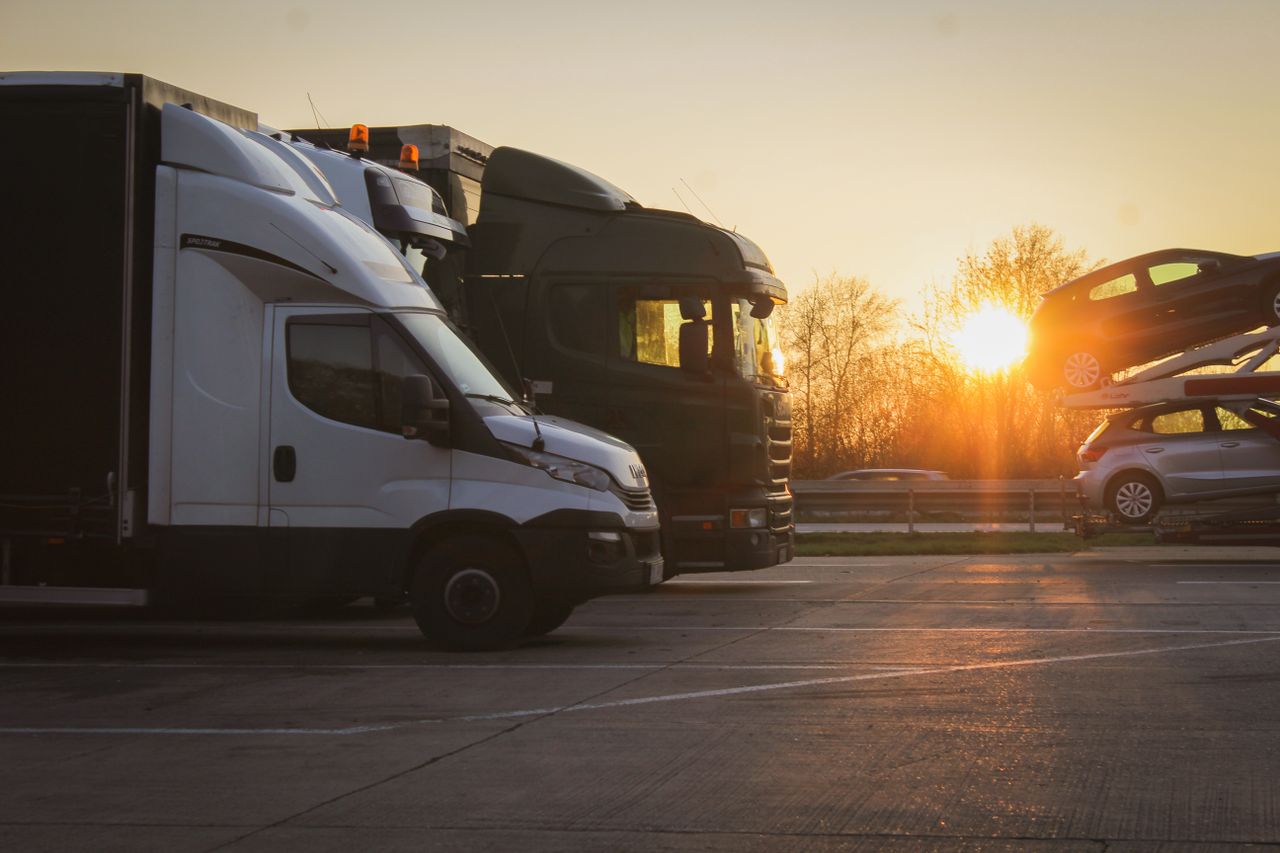 Mastering the First Impression: Your intriguing post title goes here A row of trucks and car transporter parked at sunset in an open parking lot, highlighting the golden hour.